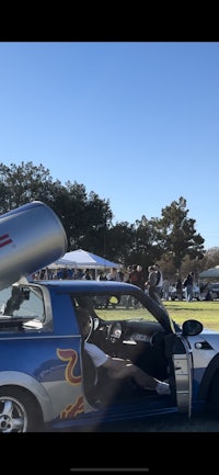 a car with a hood open and a bottle in the trunk