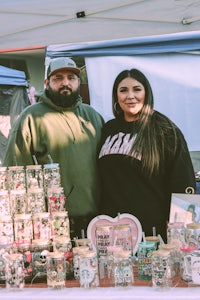 a man and woman standing in front of a table