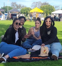 a group of people sitting on a blanket at an outdoor event